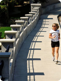 Woman jogging on a sidewalk.
