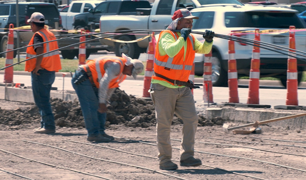 Construction worker transporting reinforcing steel