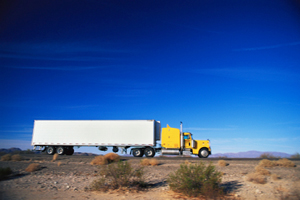 Truck on road seen against blue sky.