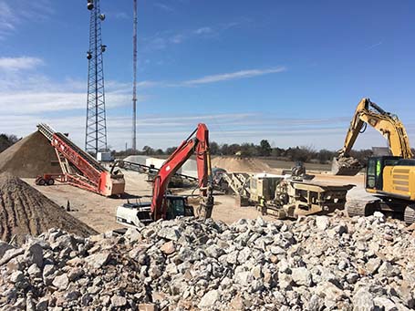 The image depicts a concrete recycling project underway.