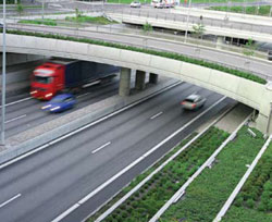 Photo. Image of traffic on a divided highway passing under an overpass carrying another divided highway.