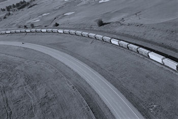 Photo. Open highway running parallel with freight train.