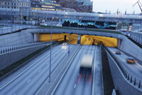 Photo. Traffic entering a city tunnel at dusk.