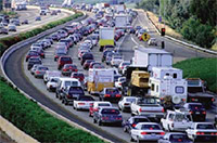 Four-lane expressway with merge lane is shown with traffic backed up in all lanes.