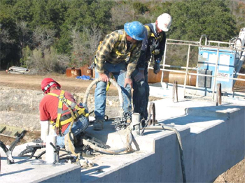 This figure is a photo showing the grout being pumped into the post-tensioning ducts.