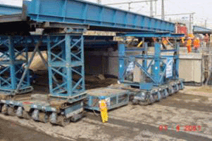 Picture showing several units of the self-propelled modular transporter systems tied up together to carry an entire bridge span.