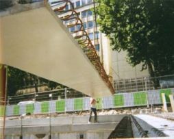 Poutre Dalle span is being erected on a bridge site in France. Note that field forming between span for the deck has been eliminated when panels are placed side-by-side. A field cast-in-place deck pour with the robust joint details ties the panels monolithically. (Photo Courtesy Central Laboratory for Public Works)