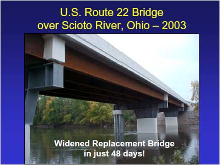 U.S. Route 22 Bridge after construction. The widened bridge crosses the Scioto River. The existing piers are topped with new galvanized steel plate girder bent caps that extend to groups of four concrete-capped galvanized steel pipe piles under the widened portion of the bridge. Five new steel girders per span support the concrete deck and traffic railing.