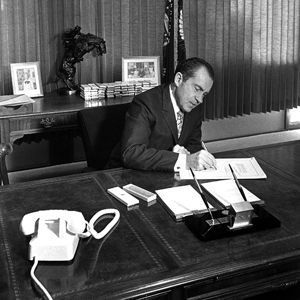 Black and white commemorative photograph of President Nixon signing the National Environmental Policy Act.