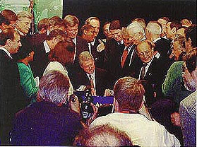 Photograph of people crowded around President Clinton as he signs the Transportation Equity Act for the 21st Century.