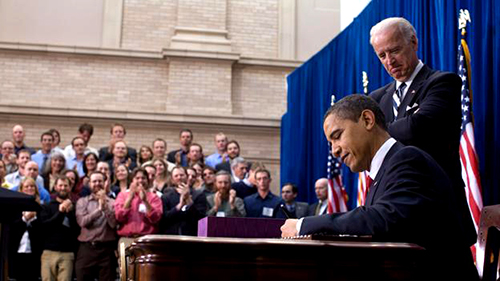 Photograph of President Obama signing the American Recovery and Reinvestment Act (ARRA) with Vice President Biden overlooking.