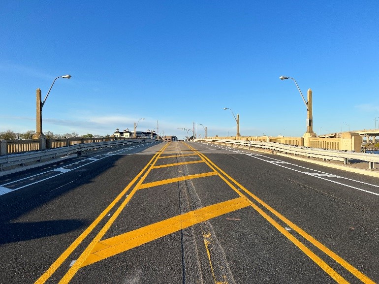 Bold Steps Award - two lane roadway with yellow centerlines and a blue sky.