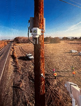 Utility Pole with MUST device attached in a rural road area.