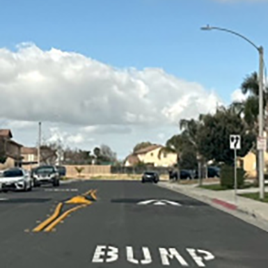 A street with cars and houses on the side
