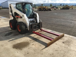 Figure 3. Modified skid steer with a bull blade and a scraper.