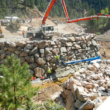 View of completed bridge with a near-vertical rockery used to build a bridge embankment in a stream.