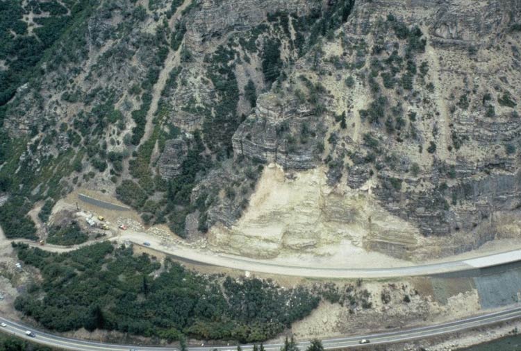 Photo. Rock excavation shortly after construction. Note the stark contrast of the freshly excavated material
                  and the naturally weathered rock surfaces. Glenwood Canyon, Colorado