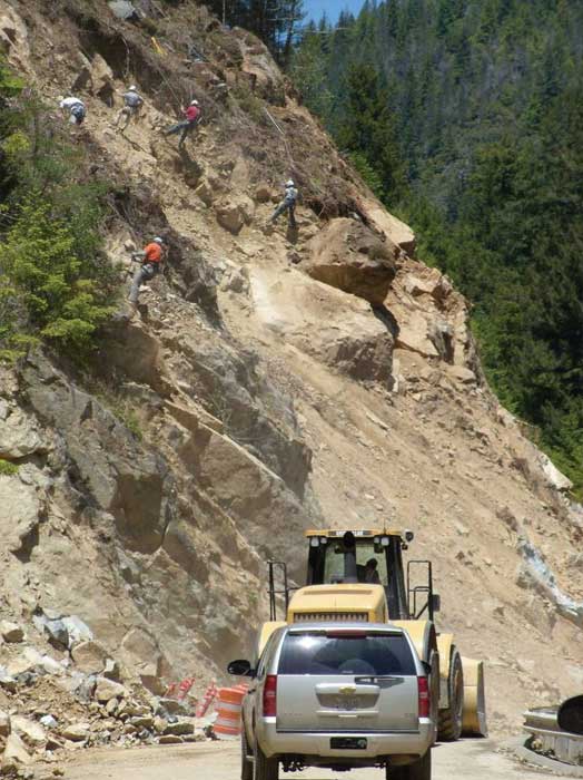Photo. Hand scalers removing loose material from a cut slope South Fork Smith River Road, California.