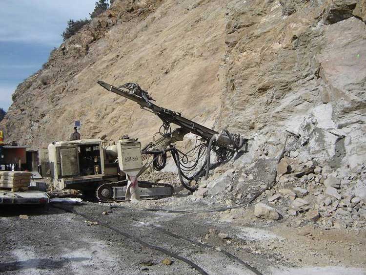 Figure 46. Photo. Installation of rock bolts using a track drill.