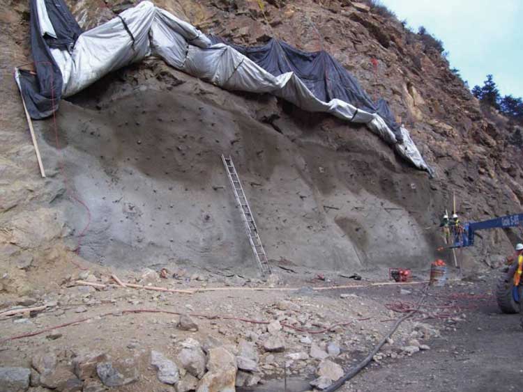 Figure 54. Photo. Installation of the first layer of structural shotcrete.