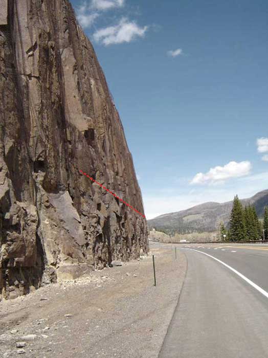 Figure 58. Photo. A rockfall-prone slope draped with unsecured wire mesh. Wolf Creek Pass, Colorado.