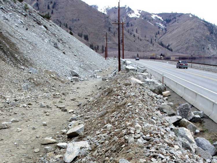 Figure 65. Photo. A conventional earthen berm can protect a highway from rockfall with low bounce height and low rotational energy.