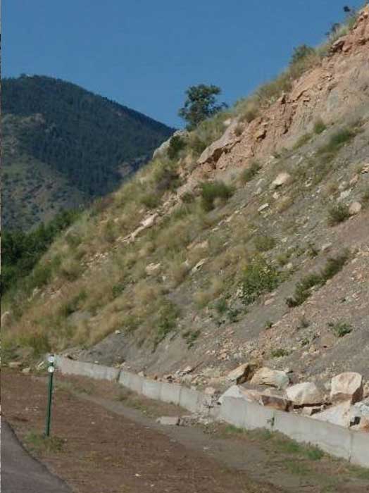 Figure 67. Photo. Concrete barriers used as a rockfall protection measure. Notice the damage caused by a large rock impact.