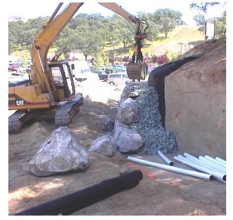 Figure 62. Photograph. Hydraulic excavator with a clamshell constructing a rockery.