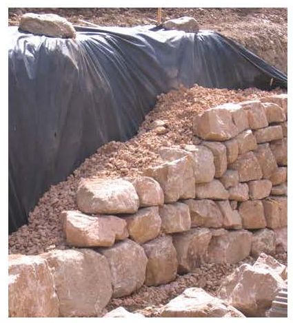 Figure 72. Photograph. Placement of drain blanket and non-woven geotextile behind rockery.