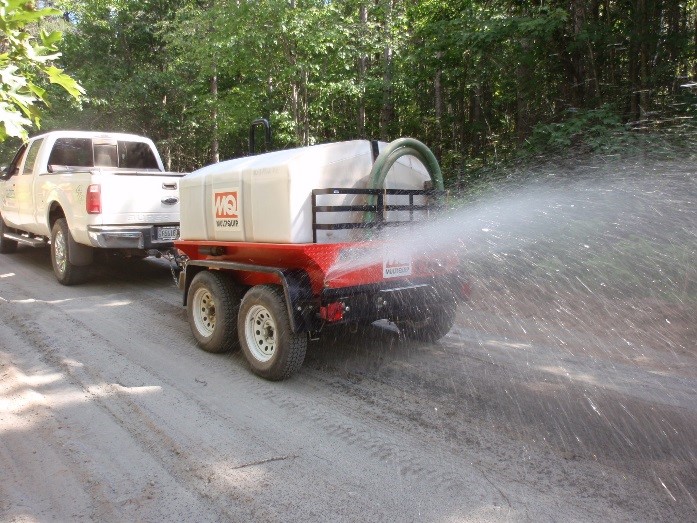 Water truck watering the ash on the road.
