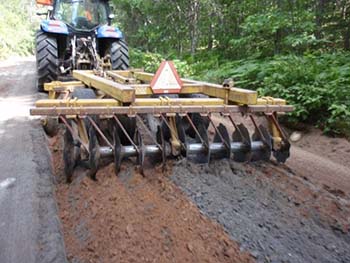 Construction vehicle blending ash and soil.