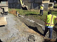 Workers digging around a pipe