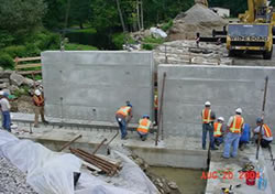 Photograph of placement of pre-cast concrete bridge abutments.