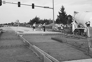 Workers laying concrete at an intersection
