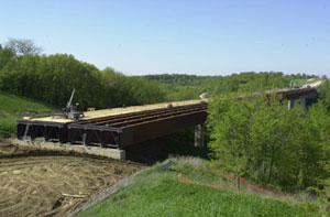 Figure 8. Photo. Iowa River Bridge. The Iowa River Bridge in Hardin County, IA. The bridge was assembled on one side of the river and rolled 496 m (1,630 ft) across the river valley into position.