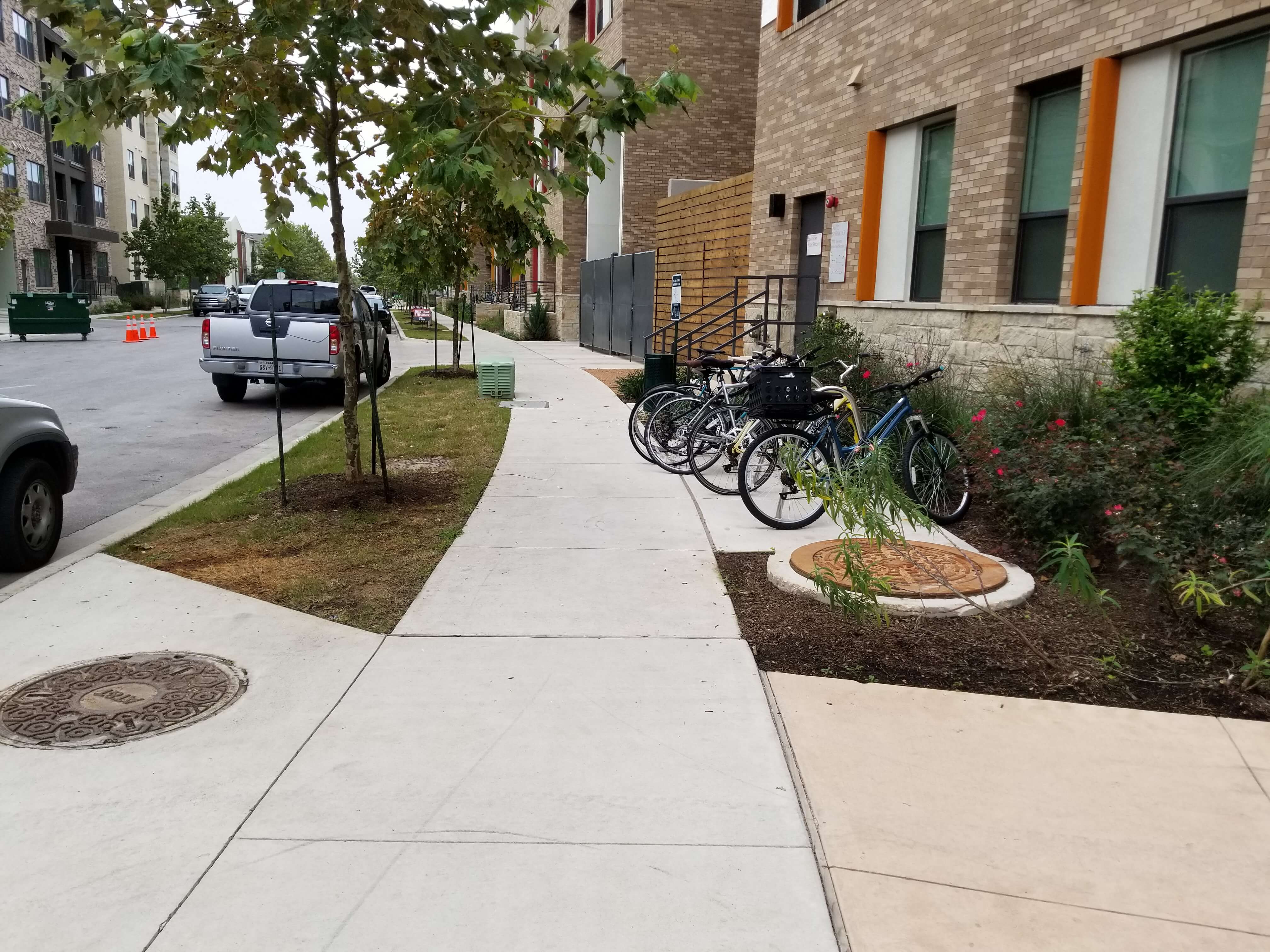 The design incorporates a designated spot between the building and sidewalk to a building for the parking of bicycles.