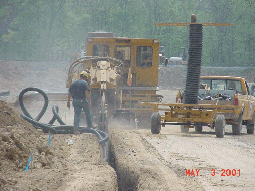 Photo of digging a trench and installing perforated pipe for an underdrain to help stabilize the subgrade.