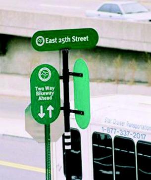 Photo of a street sign, East 25th Street, Two Way Bikeway Ahead.