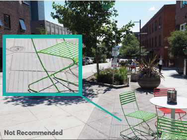 Photo of the ede of a shared street. The shared zone is a light gray. The treatment used to indicate the edge of the shared zone--a corduroy pattern--is a slightly darker gray.