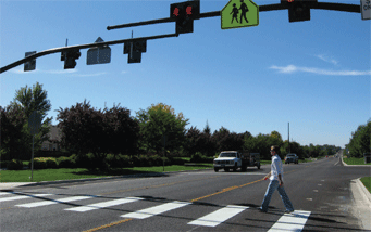 Photograph of a person crossing the street at a crosswalk.