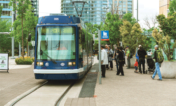 Photograph of people boarding a street tram.