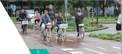People riding along smooth, marked separated bike lane.