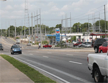 Image is a scene of a wide, multi-lane road without pedestrian crossings.