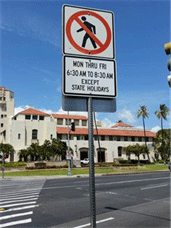 Image shows a roadway with confusing signage limiting pedestrian crossing.