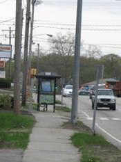 Image shows a bus stop obstructing the sidewalk.