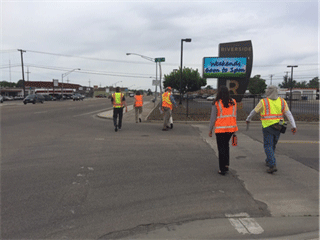 Image shows pedestrians crossing in a faded crosswalk.