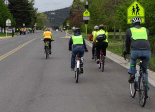 Image shows bicyclists without a bike lane riding in a lane of traffic.