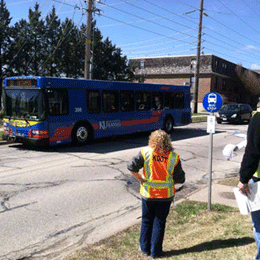 Image shows a bus stop and assessment participant.