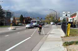 Photo of bicyclist riding in bike lane approaching intersection.