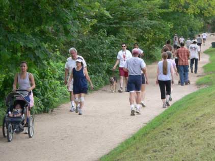 Photo of people biking and walking along a paved trail.